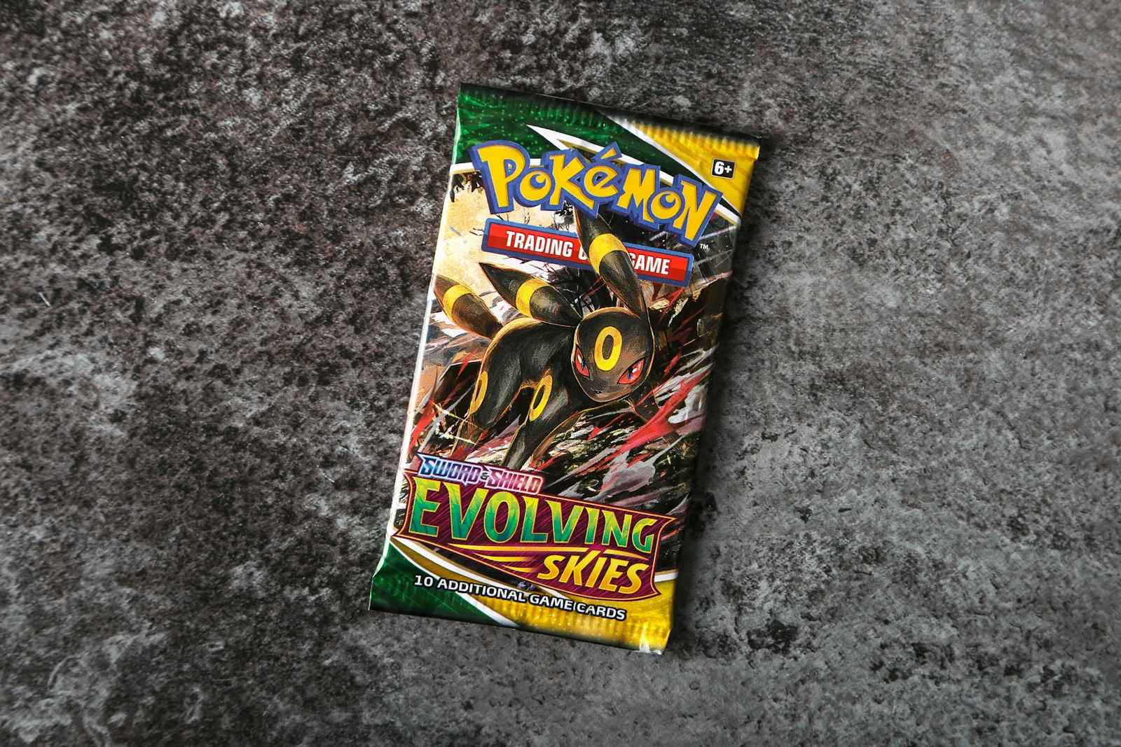 Busta inglese Pokémon Evolving Skies con Umbreon su una superficie grigia; foto illustrativa.