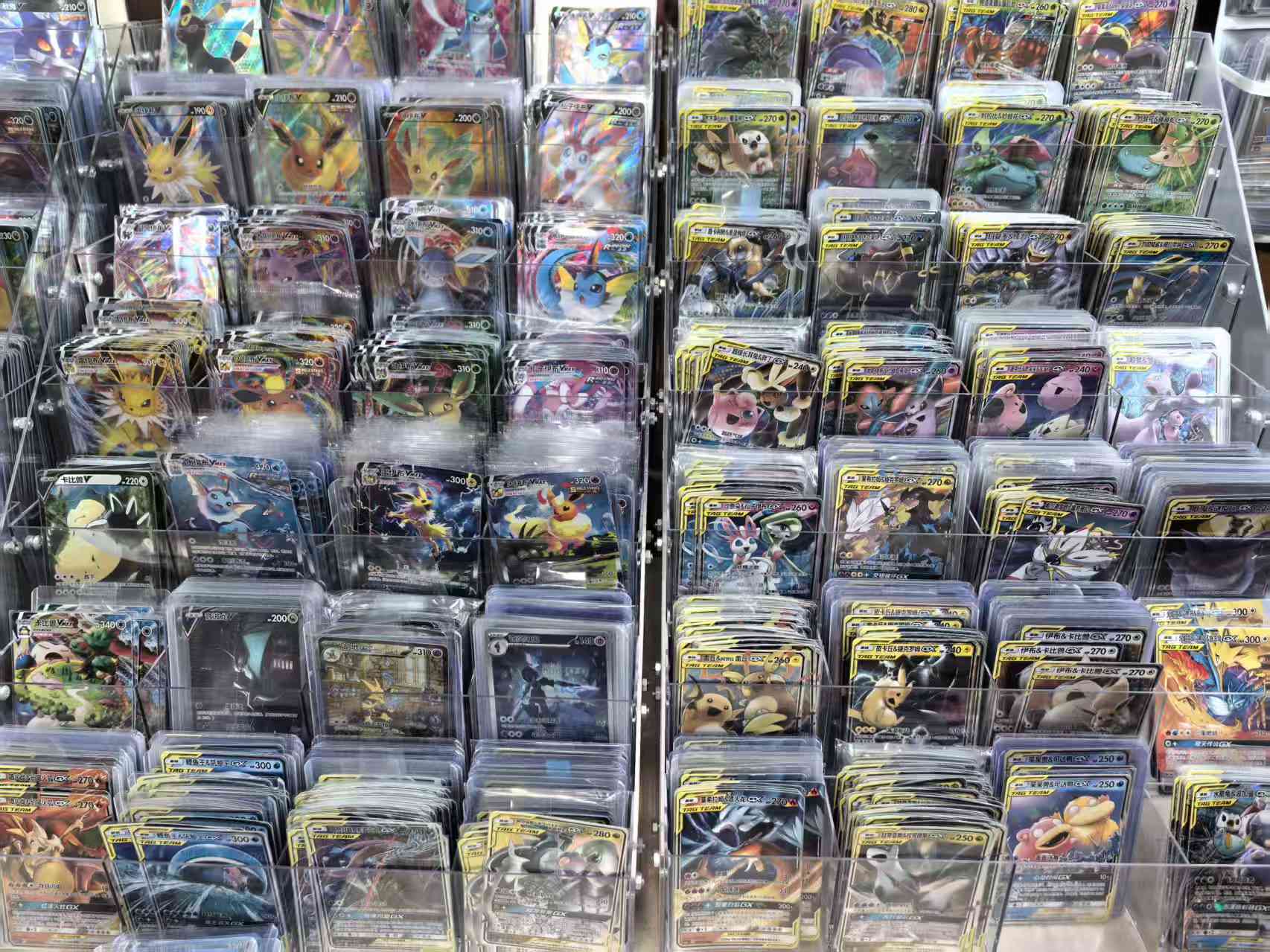 Carte Pokémon reali in cinese semplificato organizzate in vaschette trasparenti